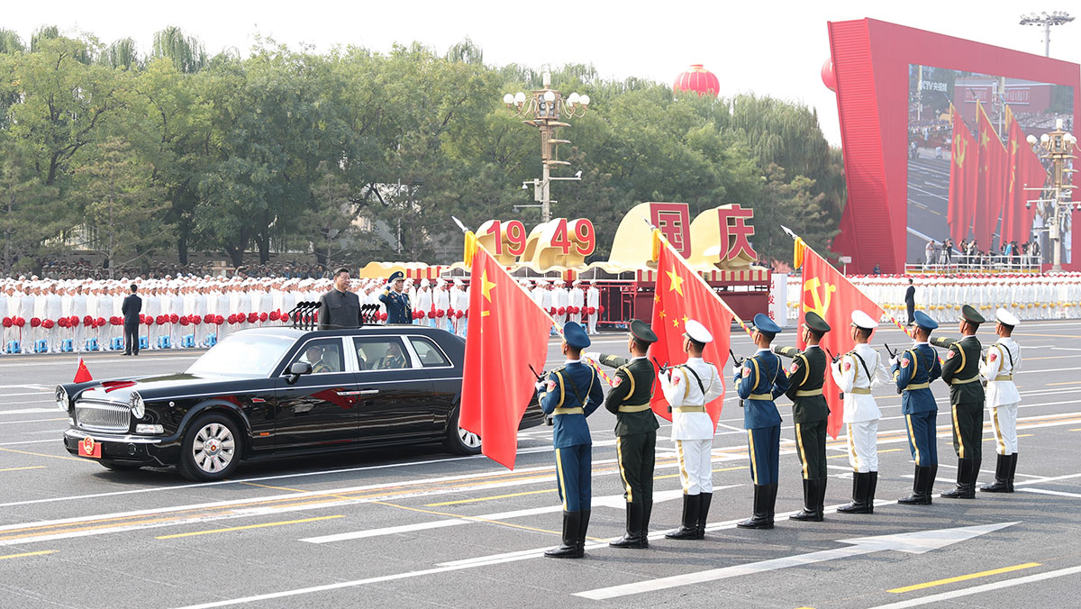 習(xí)近平驅(qū)車行進至黨旗、國旗、軍旗前，向旗幟行注目禮