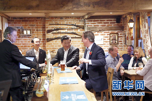 這是會晤結束后，習近平在卡梅倫陪同下乘車前往當?shù)匦℃?zhèn)體驗酒吧文化。新華社記者 鞠鵬 攝
